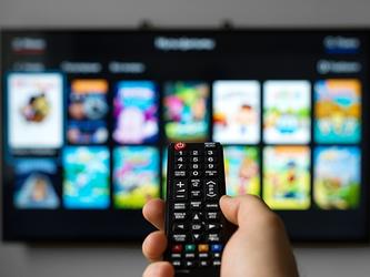 Person using remote in front of smart TV